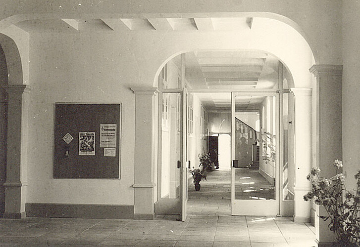 Ein Gang im Erdgeschoss des Klosters Marienwerder, der mit einer gläsernen Tür abgetrennt ist.