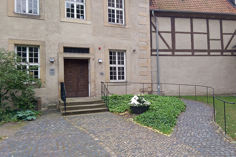 Die Eingangstür zum Kloster Marienwerder mit Treppe sowie in leichtem Schwung geführter Rampe für Rollstühle.