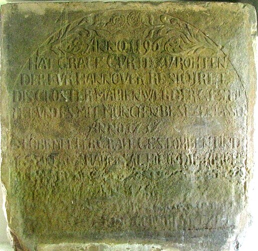 Ein aus Sandstein gefertigtes Relief mit einer Inschrift.